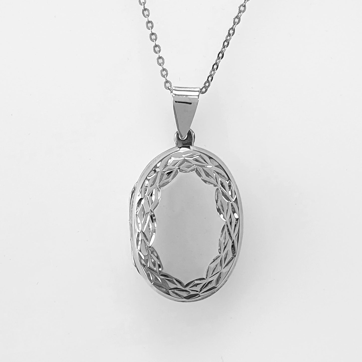 Large oval locket with silver chain on a white background. Sterling silver