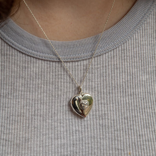 Model wearing sterling silver locket with cubic zirconia inset.