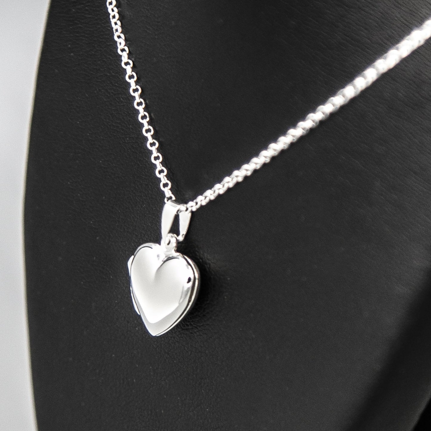 Silver heart shaped photo locket necklace on Italian silver chain against black background