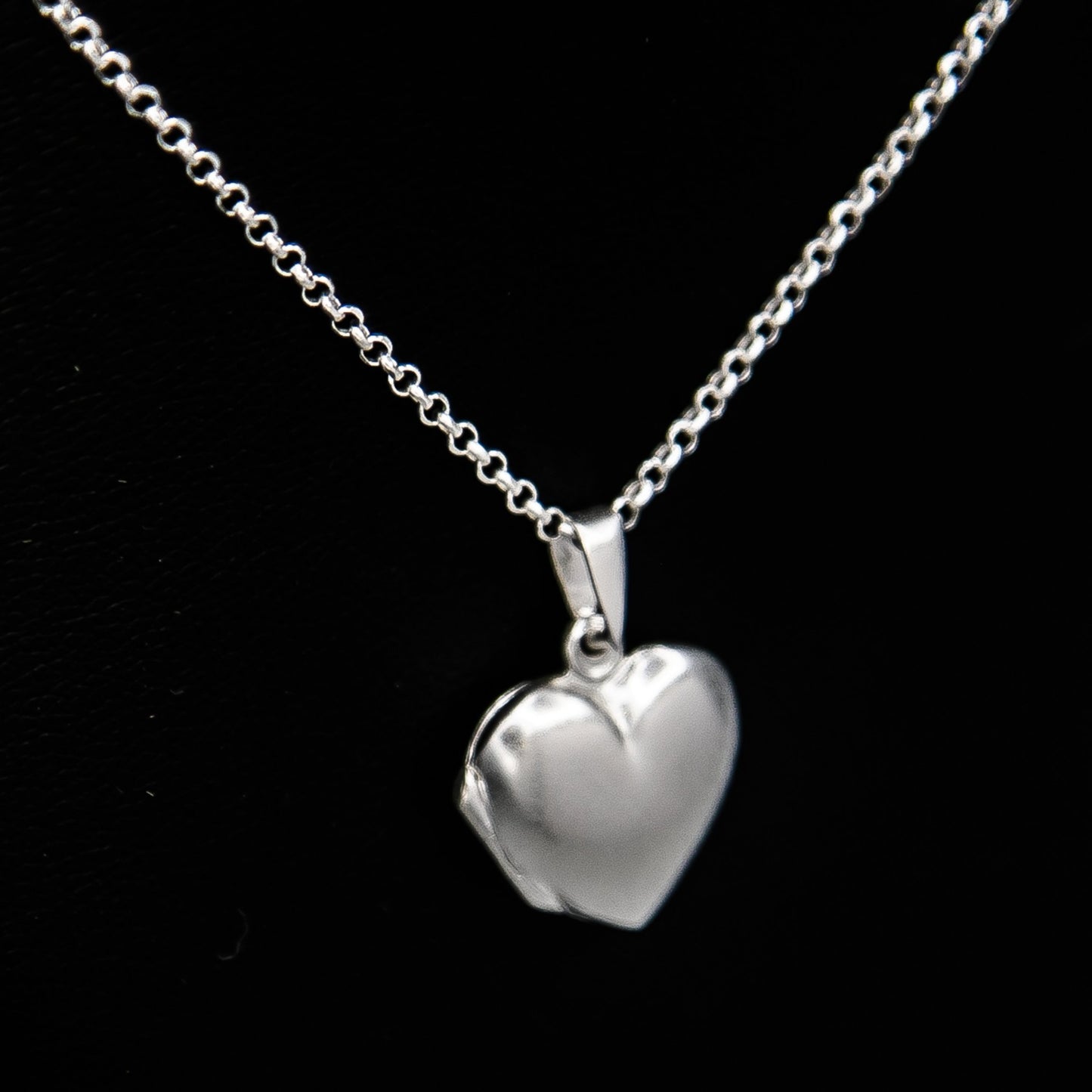 Silver heart shaped photo locket necklace on Italian silver chain against black background