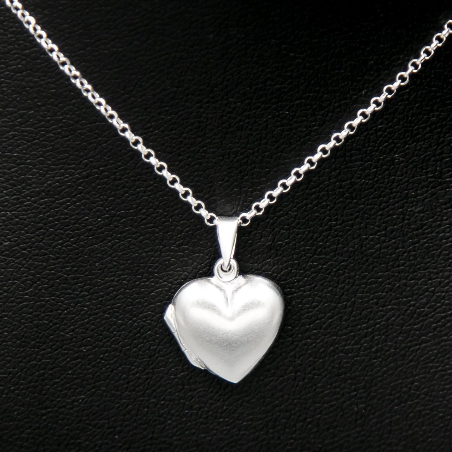 Silver heart shaped photo locket necklace on Italian silver chain against black background