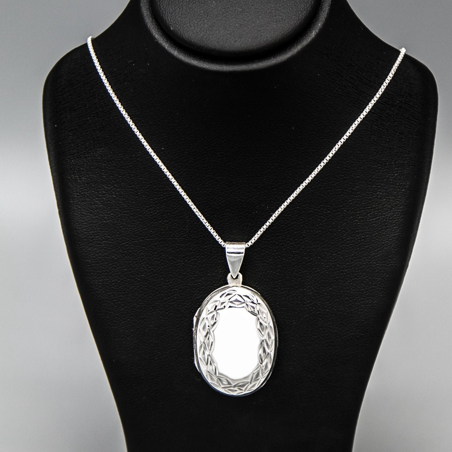 Large Oval shaped silver photo locket necklace on Italian silver chain, displayed on black bust.