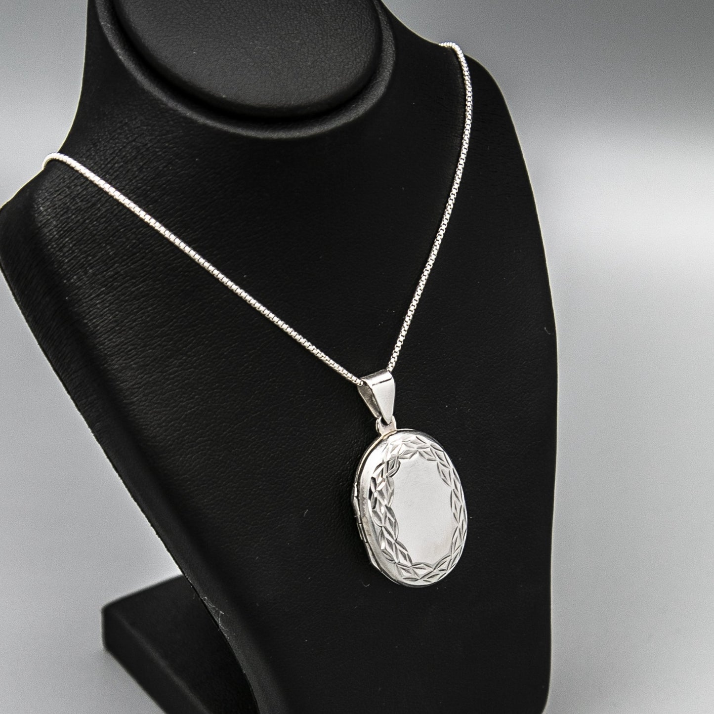 Large Oval shaped silver photo locket necklace on Italian silver chain, displayed on black bust. Complete with photos.