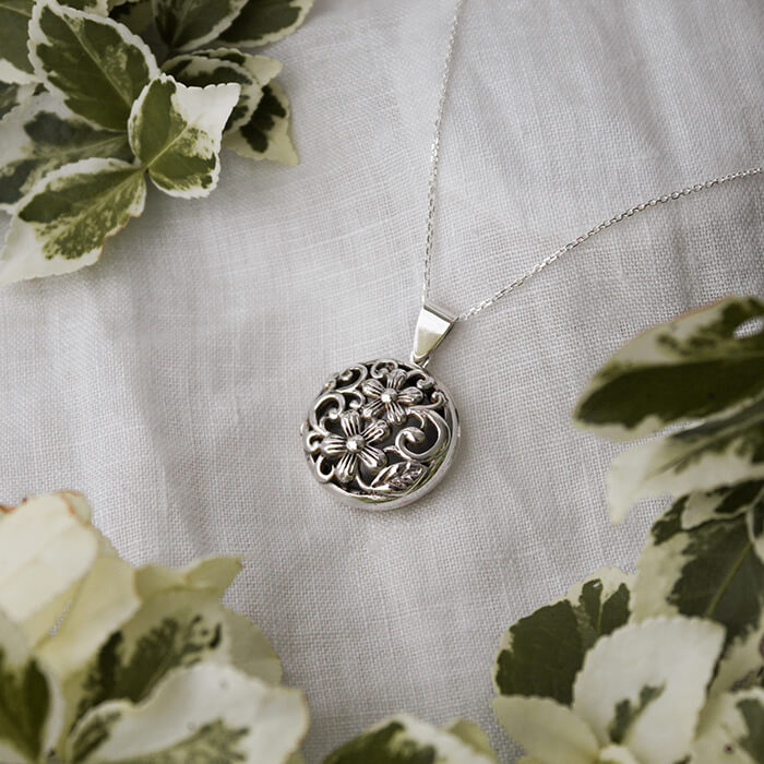 Jennifer large silver locket amid foliage
