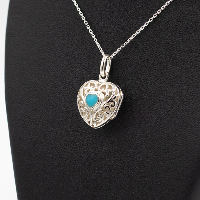 silver heart shaped locket on a black background