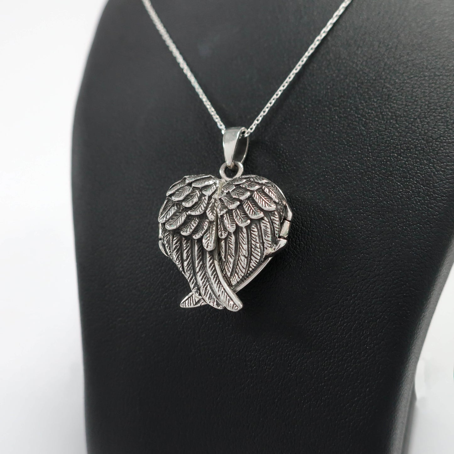 Side view of angel wings locket in silver