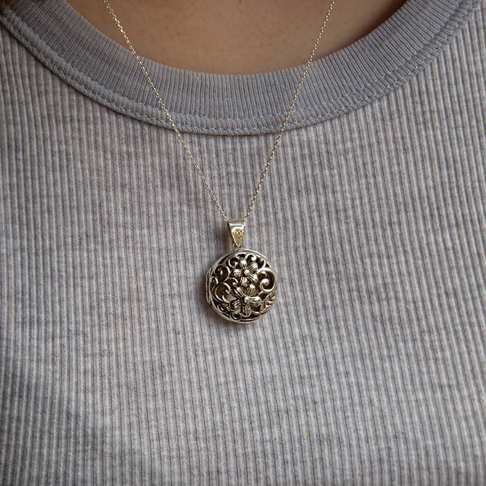 Model wearing large silver locket 