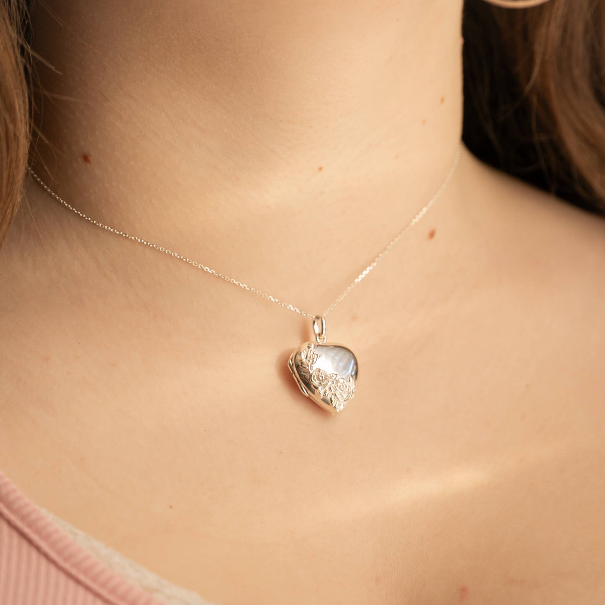 Heart-shaped pendant necklace on a person's neck