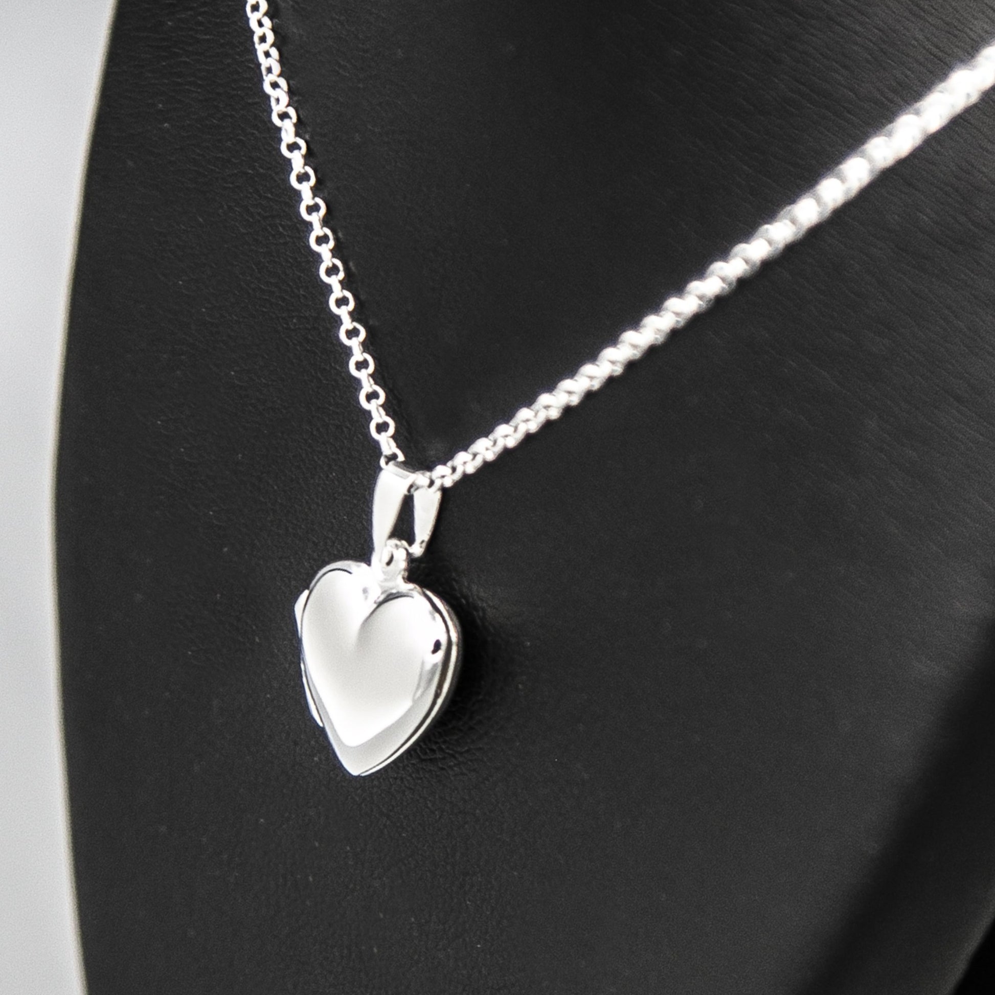Silver heart shaped photo locket necklace on Italian silver chain against black background