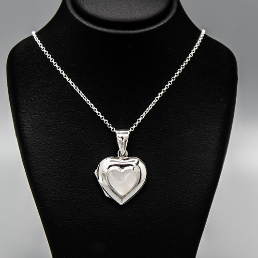Silver heart shaped photo locket pendant with white mother of pearl inset with a silver Italian chain displayed on a black bust.